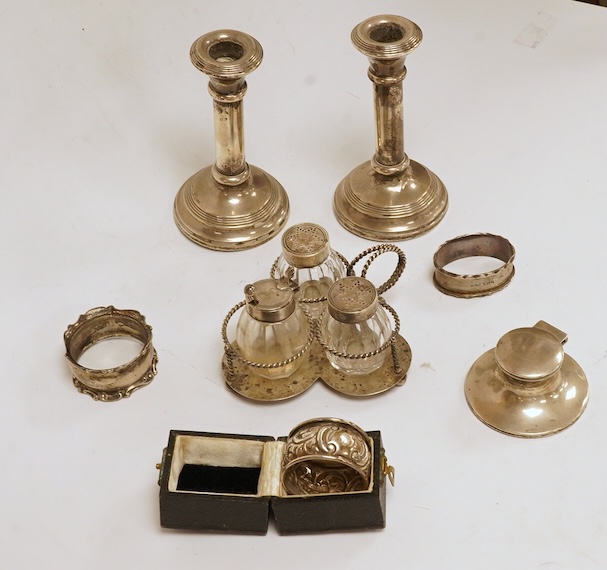 A late Victorian silver small cruet stand, with three mounted glass bottles, all Hukin & Heath, Birmingham, 1897, one associated bottle London, 1891, diameter 10.9cm, together with three assorted silver napkin rings, a s